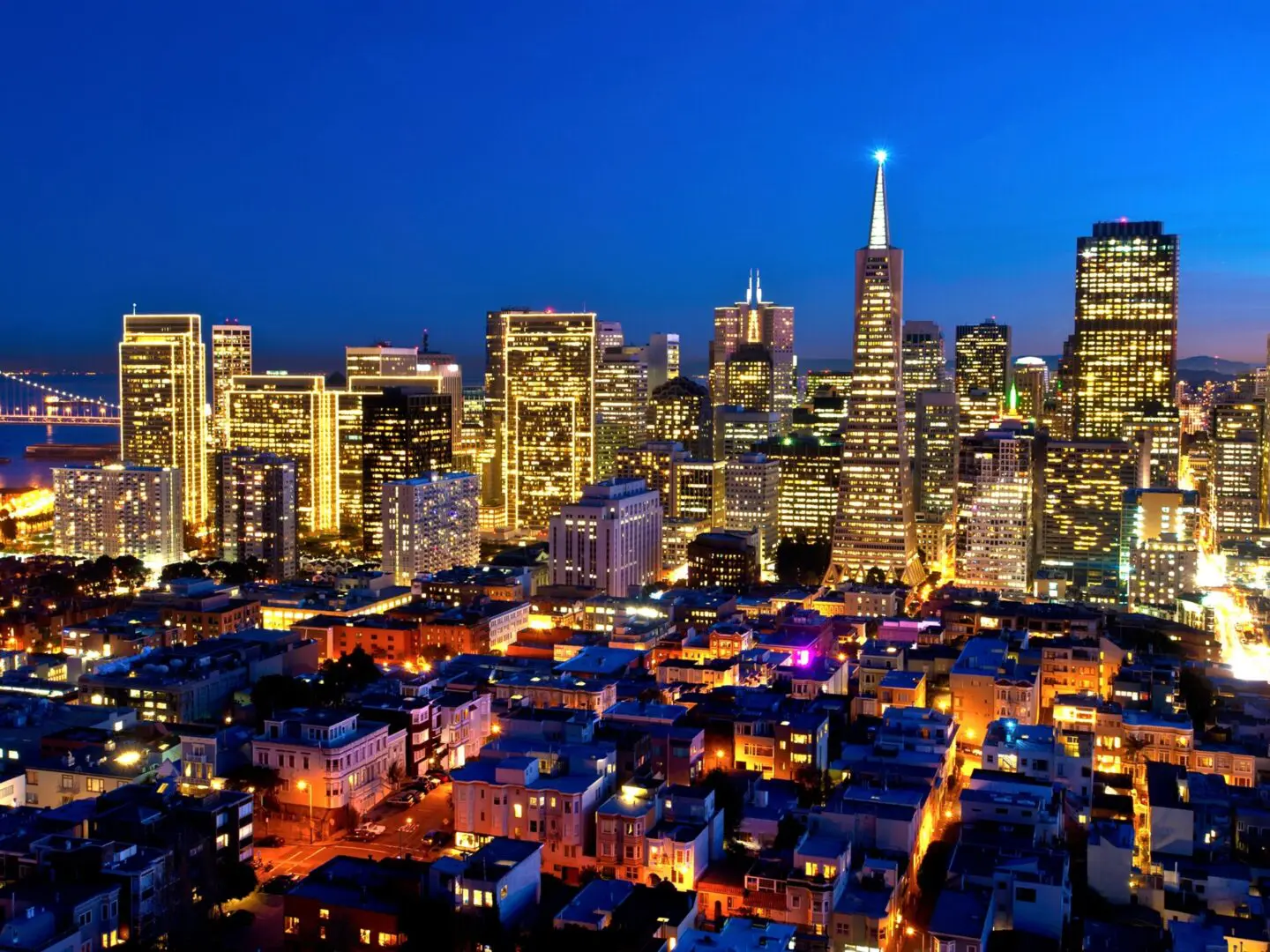 A city skyline with many buildings lit up at night.