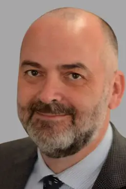 A man with a beard and mustache wearing a suit.